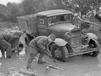 Soviet soldiers trying pulled out of the mud a stuck GAZ AA truck